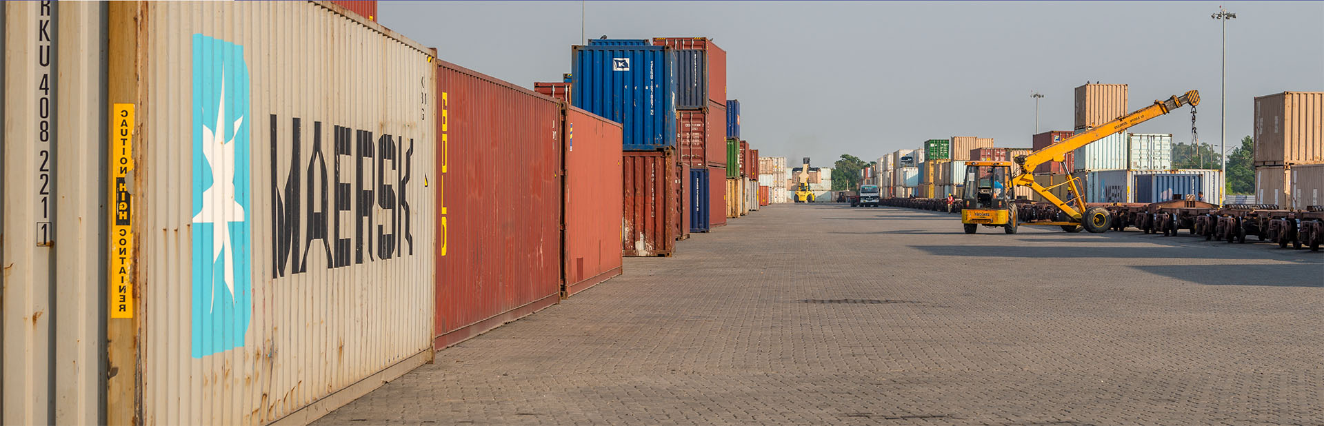 Container yard with stacked containers and reach stacker